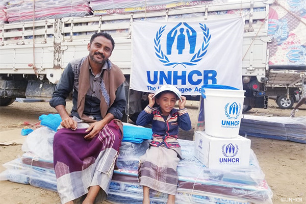 UNHCRの支援物資を受け取るイエメン避難民の父子